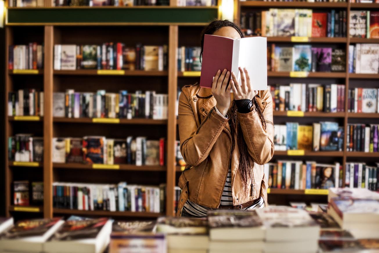 African woman reading a book at a bookstore.